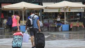 Dos turistas con una maleta.