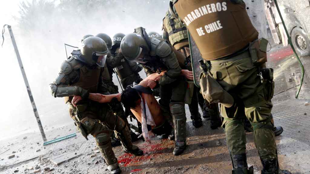 Un manifestante herido cargado por carabineros durante las protestas contra el gobierno chileno en Santiago, Chile.