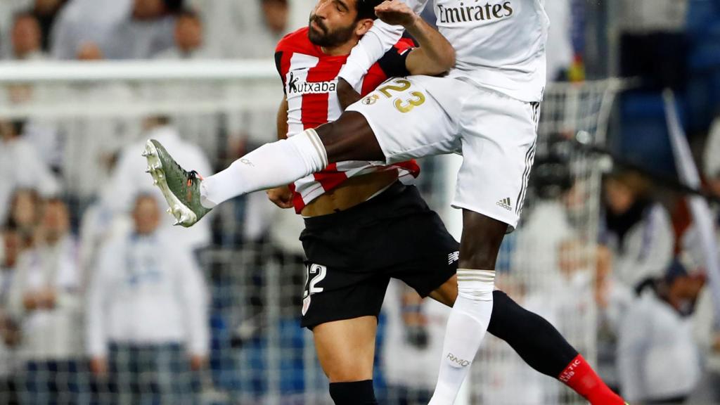 Mendy y Raúl García saltan para disputar un balón