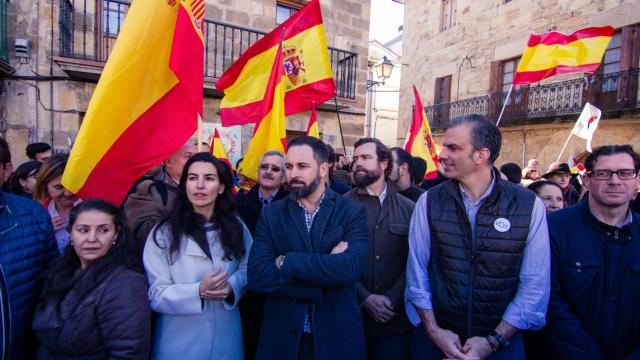 Abascal, Ortega Smith, Monasterio y Espinosa de los Monteros en un acto rodeados de banderas.