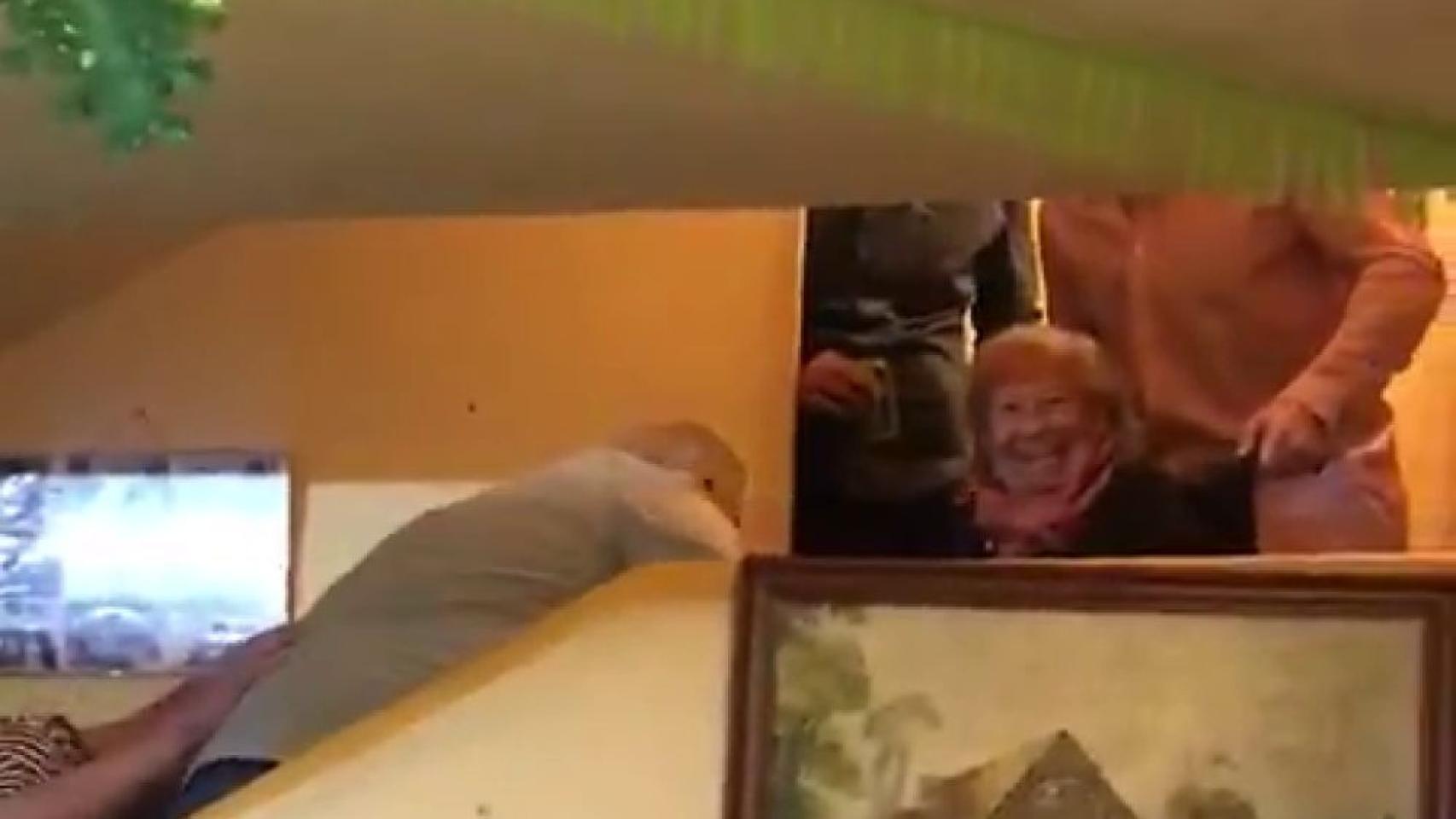 La abuela sonriendo mientras bajaban en volandas su silla de ruedas