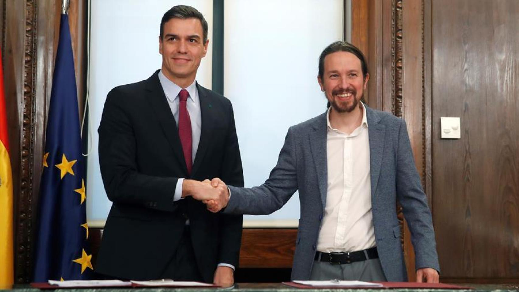 Sánchez e Iglesias estrechan sus manos durante el acto de la firma del primer Gobierno de coalición de la historia de la democracia.