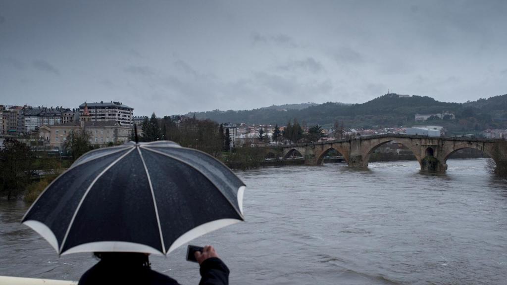 Un hombre fotografía el caudal del río Miño a su paso por Ourense. EFE/Brais Lorenzo.