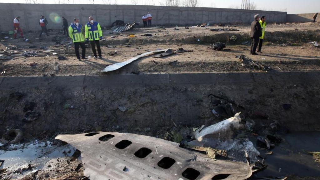 Miembros de los servicios de emergencia observan parte del fuselaje del Boeing 737 de la compañía ucraniana UIA que se estrelló en Teherán