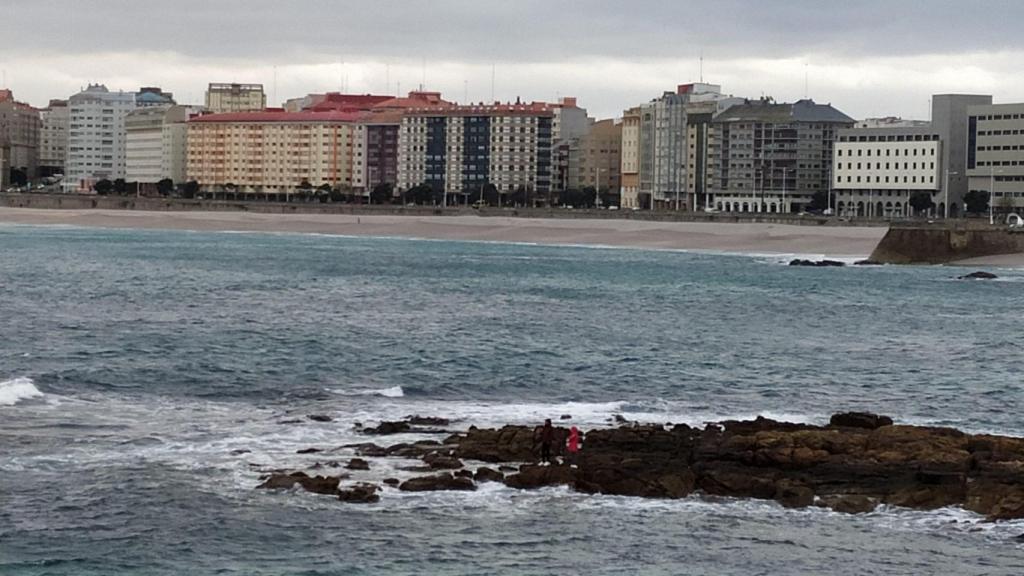 Dos jóvenes pescando en las rocas de Riazor esta tarde.