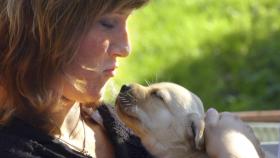 Marta Luisa de Noruega con un cachorro de perro guía en brazos.