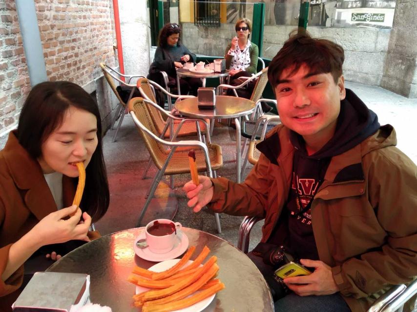 Una pareja de Corea del Sur se toma un chocolate con churros en San Ginés.