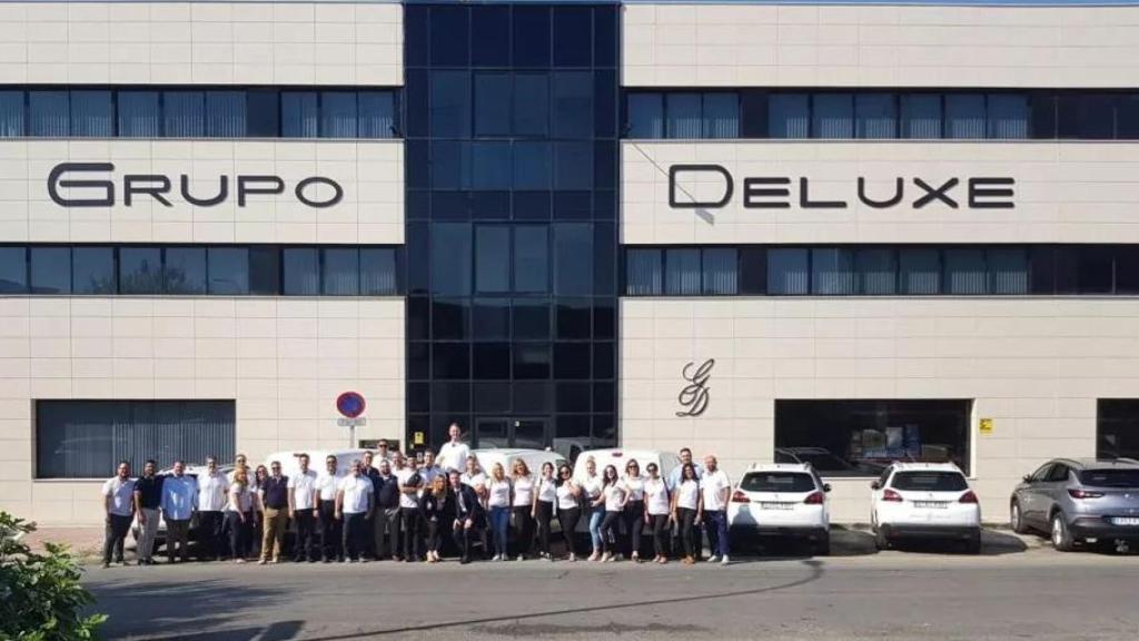 Los 42 empleados de Grupo Deluxe posan en la puerta de la empresa.