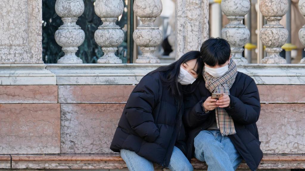 Dos turistas usan mascarillas en Venecia.