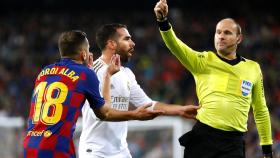 Antonio Mateu Lahoz muestra una tarjeta amarilla a Jordi Alba por una acción con Dani Carvajal