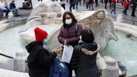 Ciudadanos con mascarilla en la plaza España de Roma.