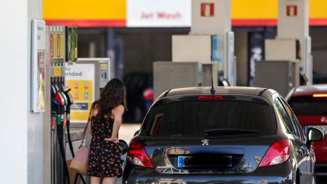 Una mujer repostando en una gasolinera.