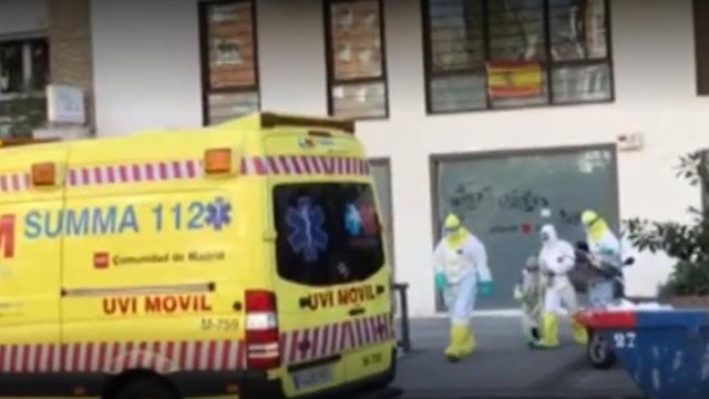 La menor, con un traje de aislamiento, sale con el personal sanitario de los Servicios del 112.