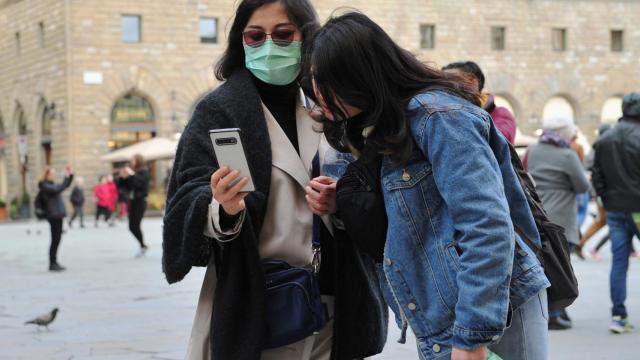 Dos turistas con mascarillas en Italia.