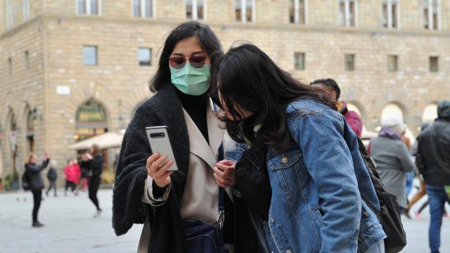 Ciudadana con mascarilla utilizando un móvil.