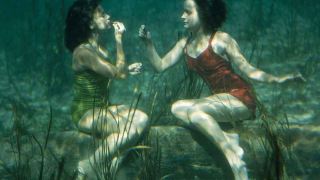 Dos artistas se pintan los labios bajo el agua.