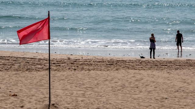 Una pareja disfruta del buen tiempo en una playa de Chiclana de la Frontera.