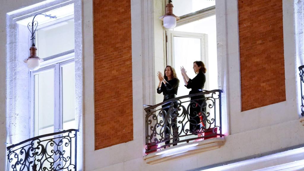 Isabel Díaz Ayuso aplaude a los sanitarios desde un balcón de la sede de la Comunidad de Madrid.