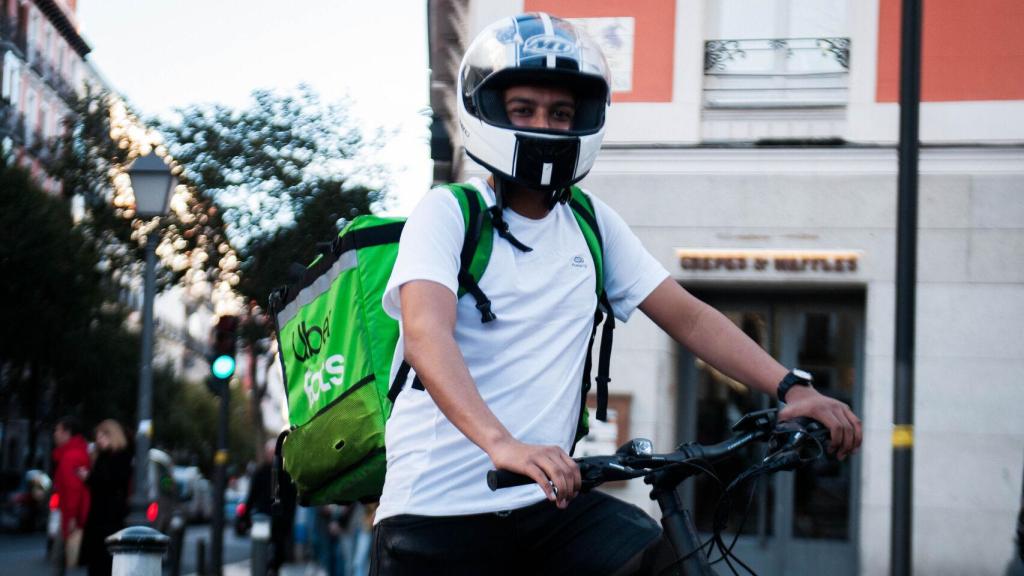 Alfredo, el único repartidor con bici que lleva casco de moto, según sus compañeros.