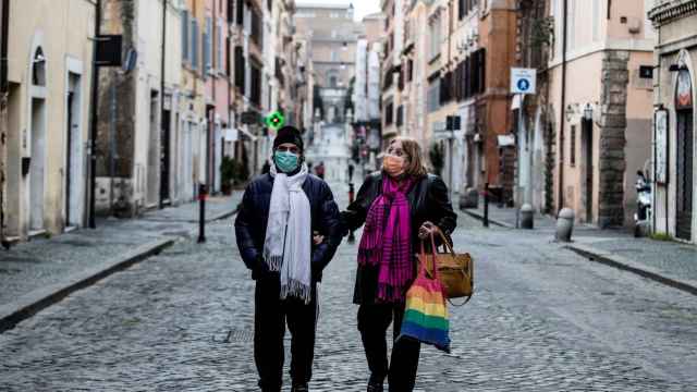 Una pareja camina por una calle desierta en Roma