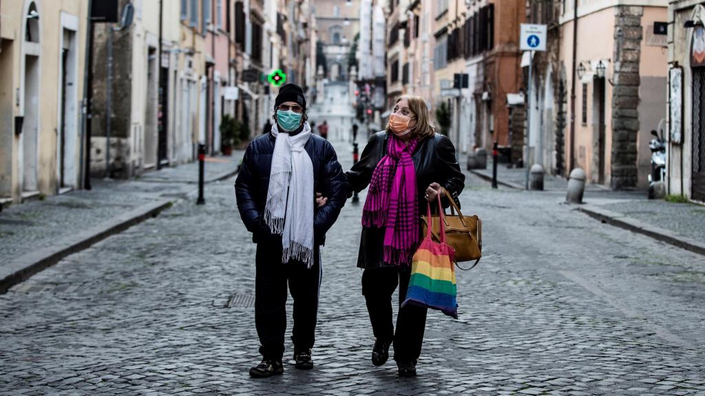 Una pareja camina por una calle desierta en Roma