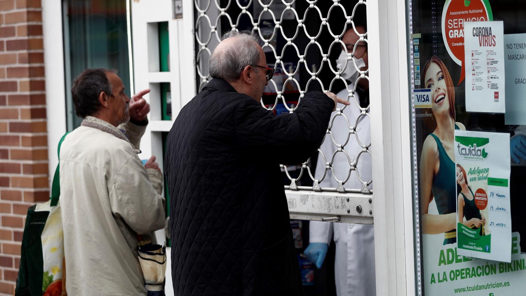 Dos personas compran medicamentos en una farmacia en Madrid.