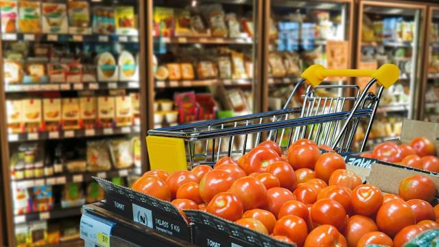 Un supermercado con varias neveras de productos en el fondo.