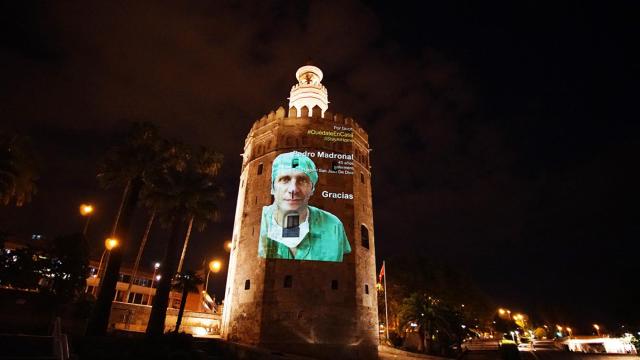 La imagen de un sanitario proyectada sobre la Torre del Oro.