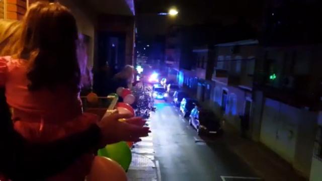 La niña Paula, junto a su madre, ve llegar por el balcón de su casa a la Policía Local de Alcantarilla.