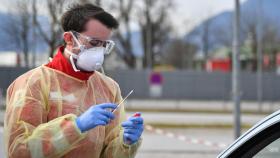 Un sanitario se dispone a tomar una muestra para un test de coronavirus.