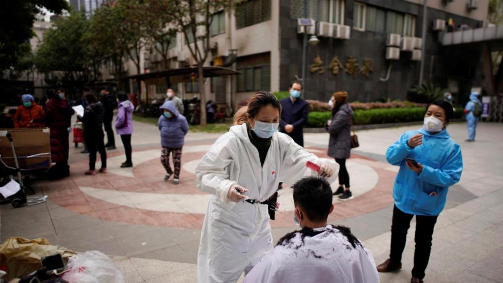 Una persona corta el pelo a otra en la ciudad de Wuhan.