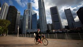 Una ciclista frente al área del Distrito Central de Negocios (CBD) en Singapur.