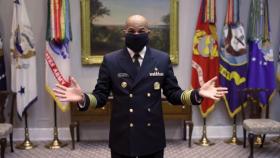 El Dr. Jerome Adams, jefe médico del Ejército de EEUU, demostrando la mascarilla que acaba de fabricar.