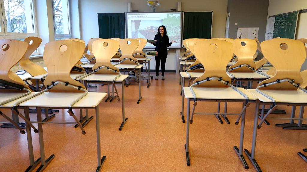 Una profesora da clases virtuales ante un aula vacía.