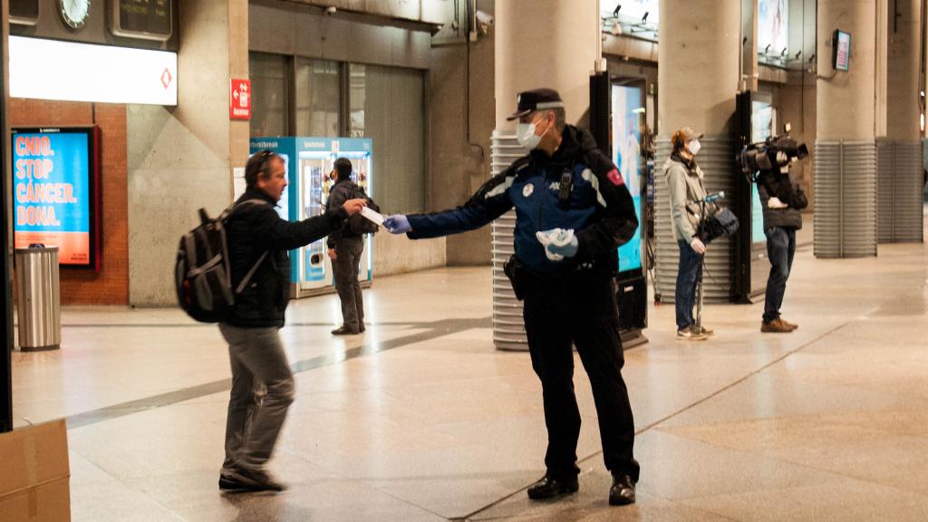 Un agente despacha mascarillas en el vestíbulo de Atocha.