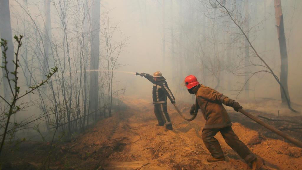 Bomberos ucranianos tratan de sofocar el incendio en las cercanías de Chernóbil.