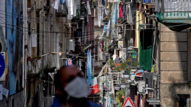 Un hombre con mascarilla camina por las calles de Nápoles