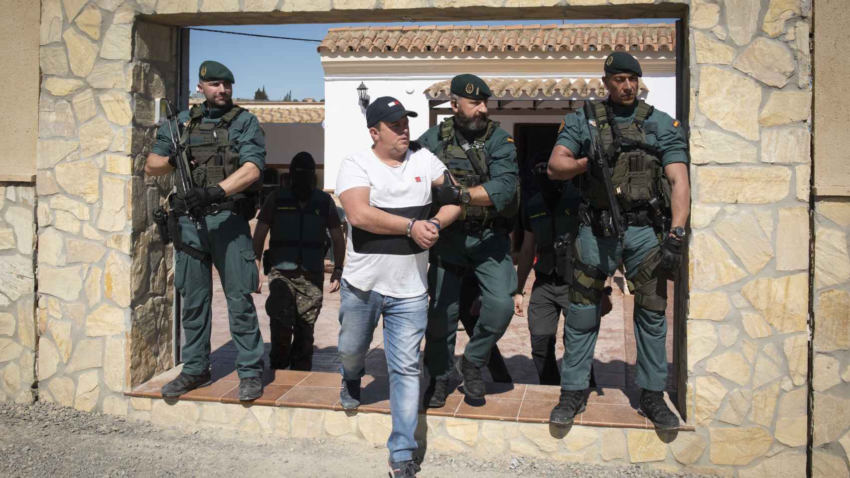 Instante en el que la Guardia Civil traslada a uno de los detenidos en Trebujena (Cádiz) tras la Operación Doberman