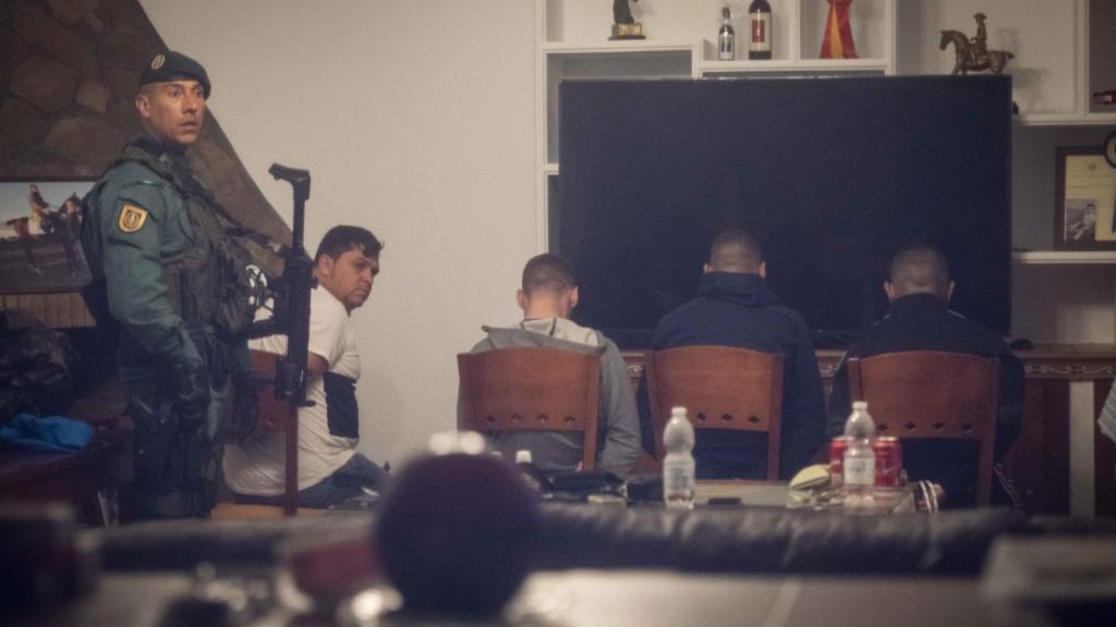 Los cuatro detenidos en un chalet de Trebujena (Cádiz), custodiados por un guardia civil.