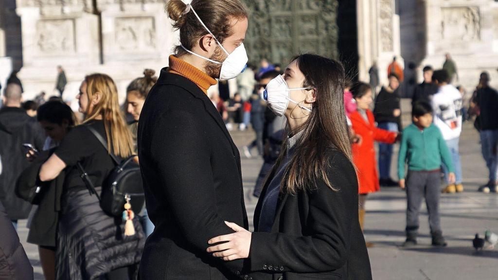 Dos jóvenes en Italia con una mascarilla protectora.