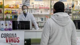 Una farmacéutico atiende a un paciente.