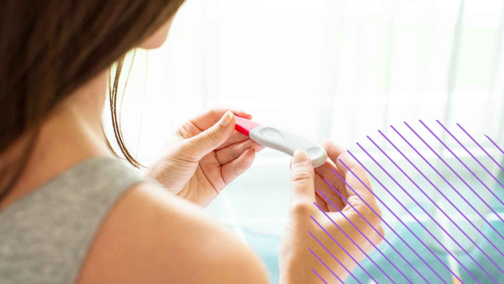 Una mujer mirando un test de embarazo.