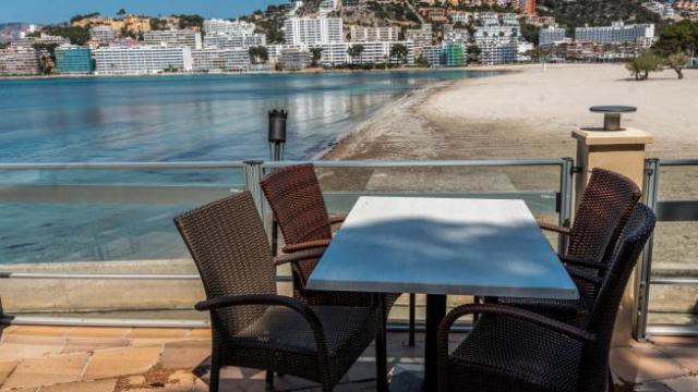 Panorámica de una terraza ante una playa.