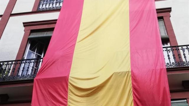 Una enorme bandera con crespón negro cuelga de un edificio particular en la plaza de El Salvador en el centro de Sevilla.