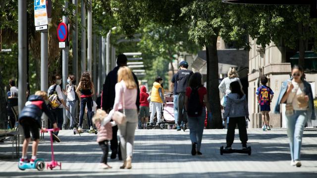 Varias familias pasean con sus hijos en la Diagonal de Barcelona.