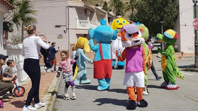 Adultos y pequeños en las puertas de sus casas en Ulea junto a La Pandilla de Drilo El Cocodrilo.