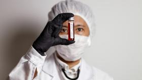 Un científico sostiene una muestra de sangre de un enfermo.