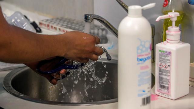 Un sanitario desinfecta material de protección para su jornada de trabajo en una planta del Hospital Puerta de Hierro de Madrid.