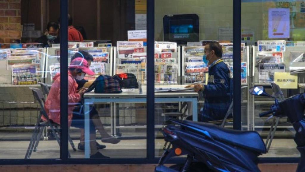 Varias personas con mascarilla en una librería.