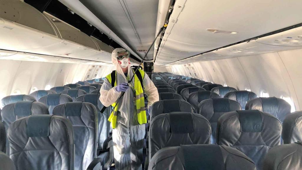 Un operario realiza tareas de desinfección de un avión.